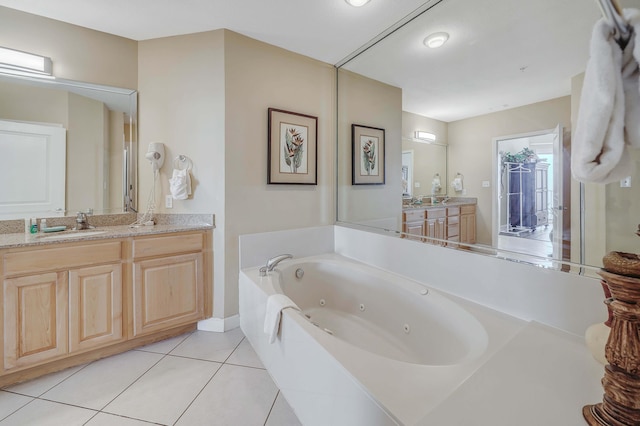 bathroom featuring tile patterned floors, vanity, and a tub to relax in