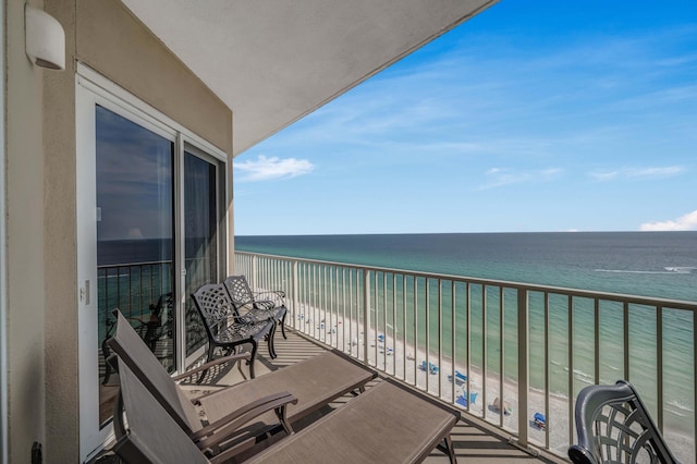 balcony with a water view and a view of the beach