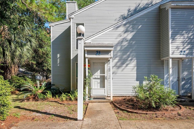 doorway to property with a chimney