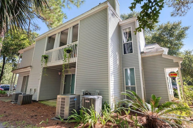 view of side of property with a balcony and central AC