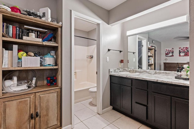 full bathroom featuring toilet, tub / shower combination, vanity, tile patterned flooring, and baseboards