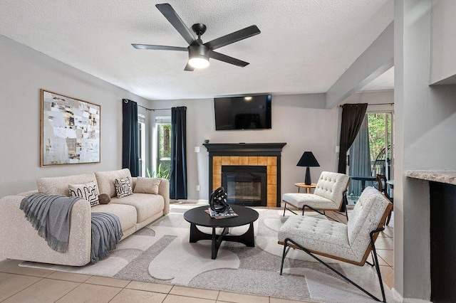 living area featuring a fireplace, plenty of natural light, a textured ceiling, and light tile patterned floors