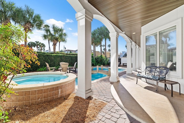 view of pool featuring an in ground hot tub and a patio