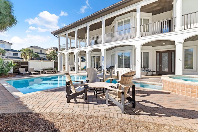 view of swimming pool featuring a patio area and an in ground hot tub