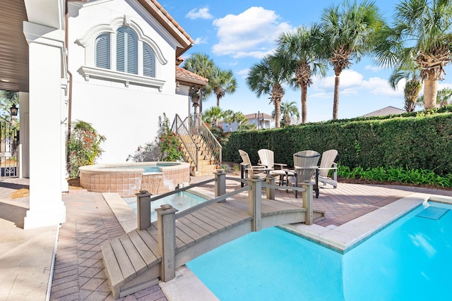 view of pool with an in ground hot tub and a patio