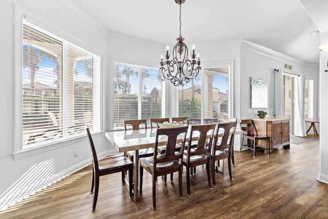 dining space with plenty of natural light, dark hardwood / wood-style flooring, ornamental molding, and a chandelier