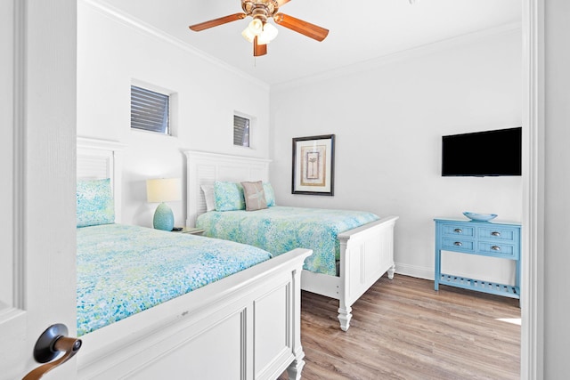 bedroom with ceiling fan, light hardwood / wood-style floors, and ornamental molding