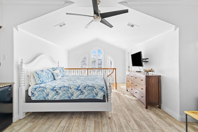 bedroom featuring ceiling fan, ornamental molding, lofted ceiling, and light wood-type flooring