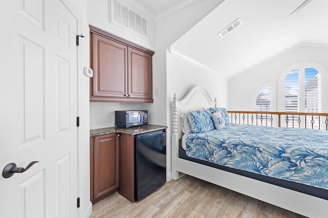 bedroom with vaulted ceiling, crown molding, light hardwood / wood-style flooring, and fridge