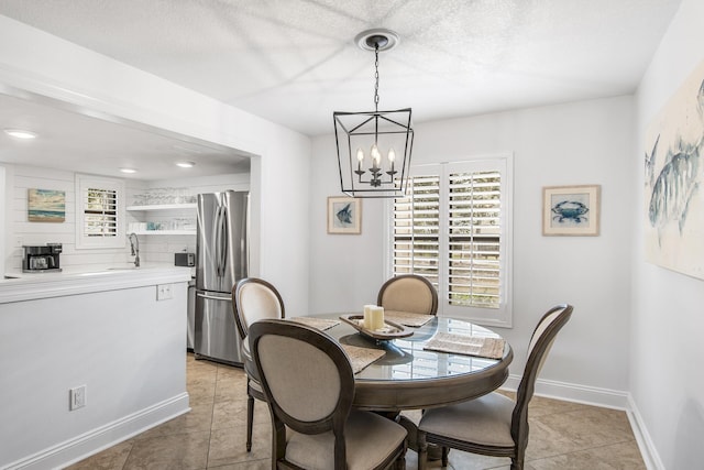 dining room featuring light tile patterned floors, sink, and an inviting chandelier