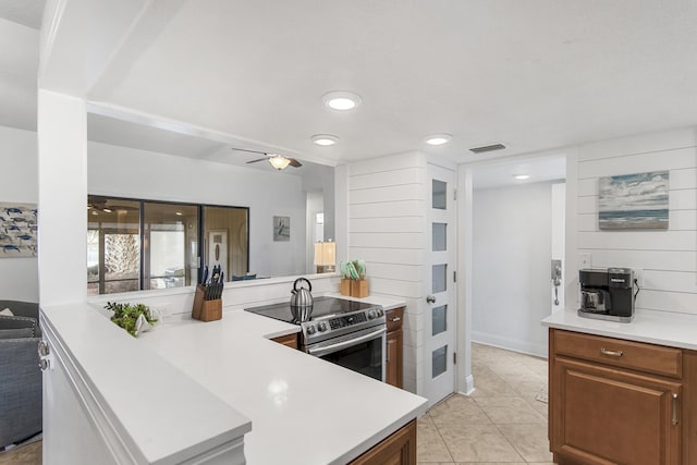 kitchen featuring light tile patterned floors, stainless steel electric range oven, and ceiling fan