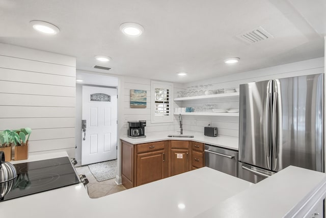 kitchen featuring decorative backsplash, sink, light tile patterned floors, and appliances with stainless steel finishes