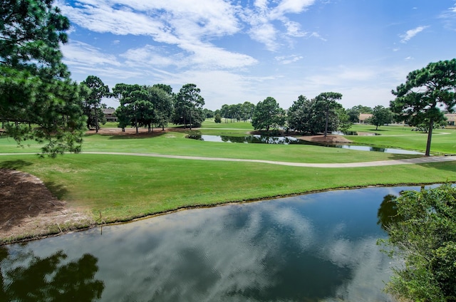 surrounding community featuring a water view and a lawn