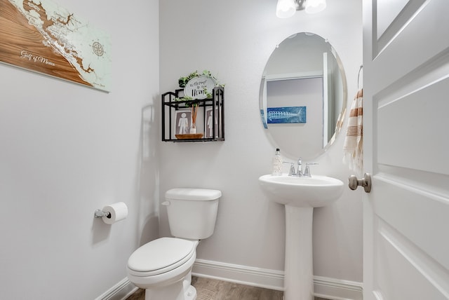 bathroom with hardwood / wood-style floors, toilet, and sink