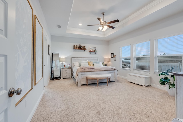 carpeted bedroom with ceiling fan, a raised ceiling, and ornamental molding