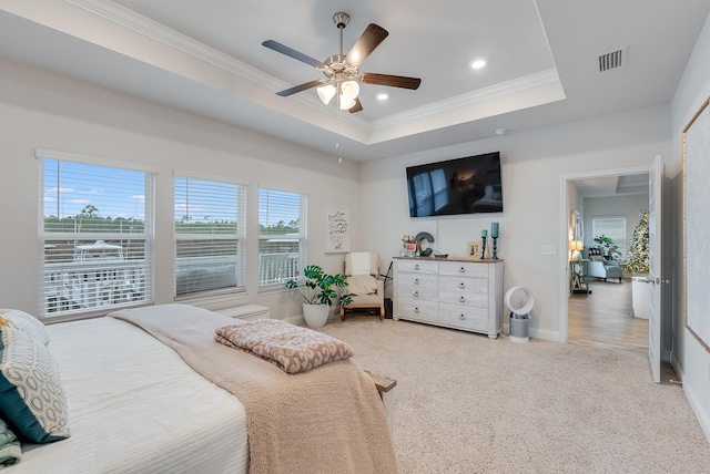 bedroom featuring a raised ceiling, ceiling fan, carpet, and ornamental molding