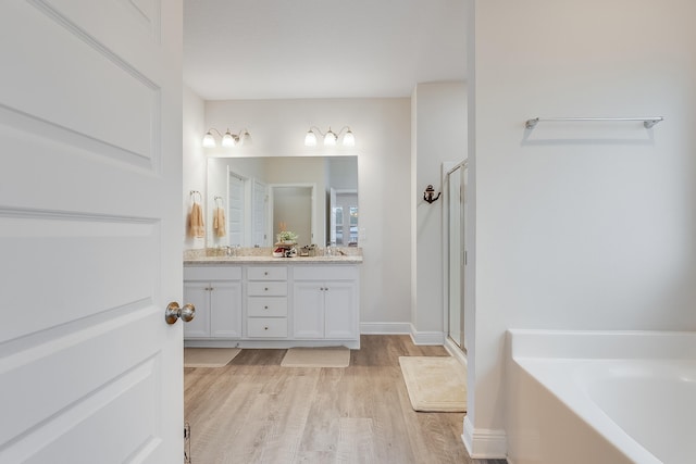 bathroom featuring vanity, wood-type flooring, and shower with separate bathtub