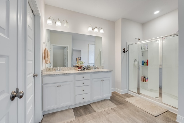 bathroom featuring hardwood / wood-style flooring, vanity, and walk in shower