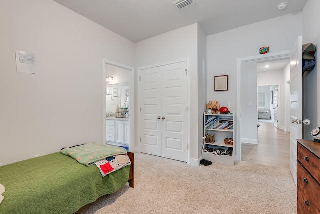 carpeted bedroom featuring connected bathroom and a closet