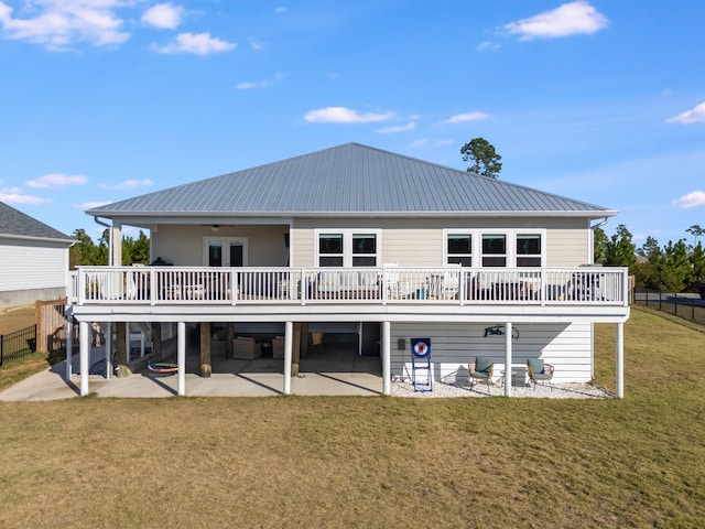 rear view of property featuring a lawn, a patio area, and a deck