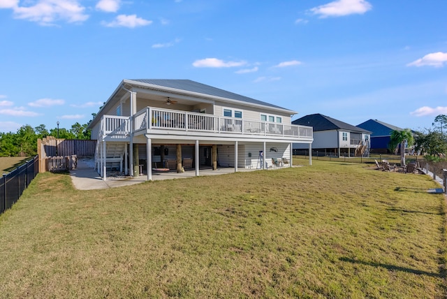 back of house featuring ceiling fan, a deck, and a yard