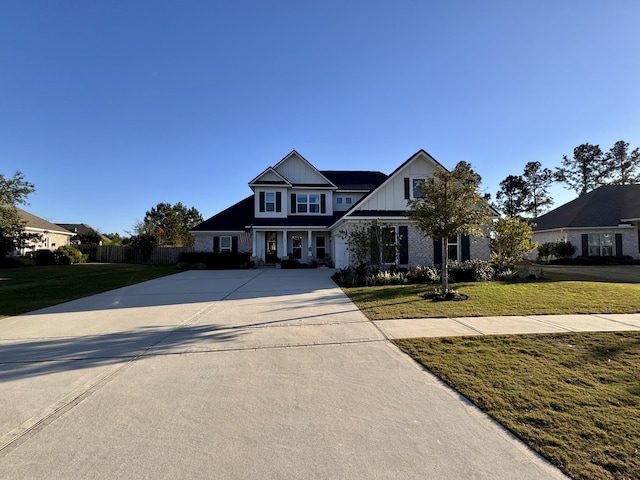 view of front of property featuring board and batten siding, concrete driveway, and a front lawn