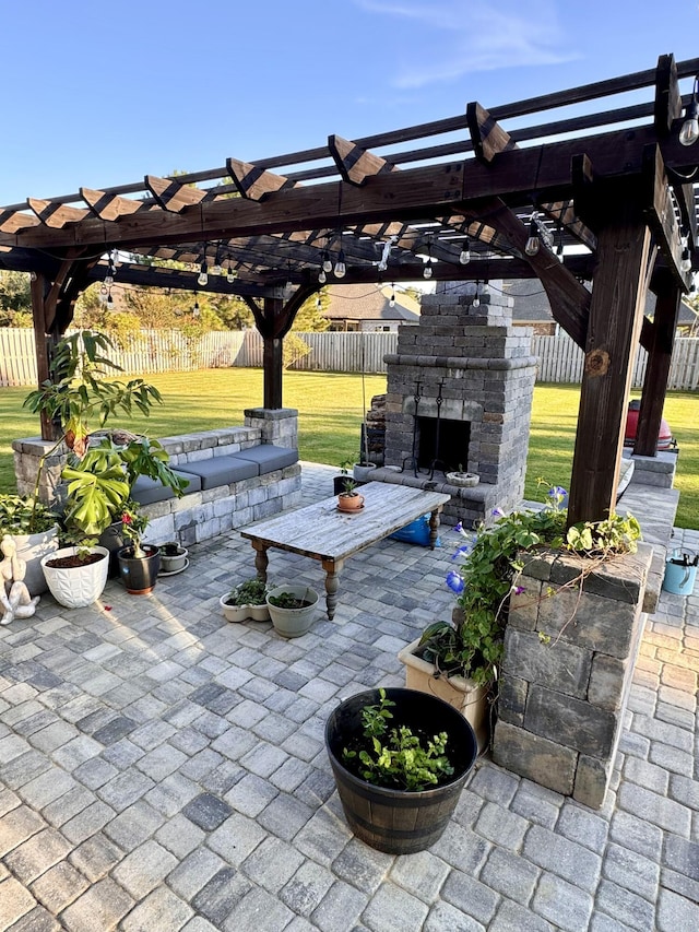 view of patio / terrace with an outdoor stone fireplace, fence, and a pergola