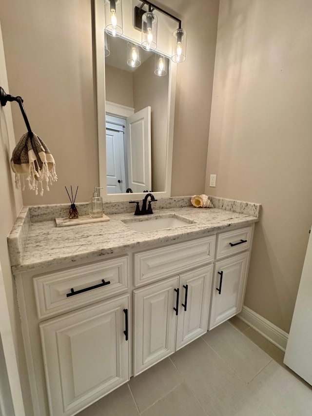 bathroom with baseboards, vanity, and tile patterned floors