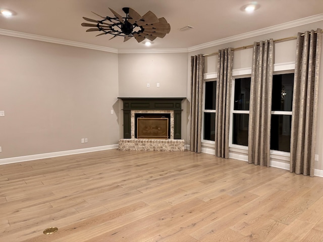 unfurnished living room with ceiling fan, ornamental molding, a fireplace, and wood finished floors