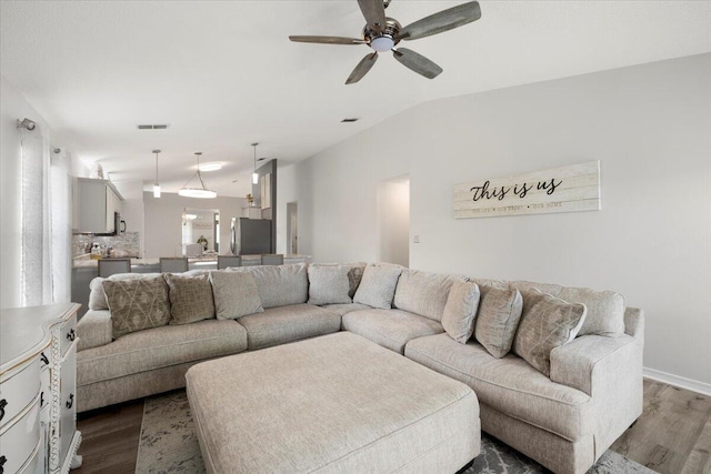 living room with ceiling fan, lofted ceiling, and dark hardwood / wood-style floors