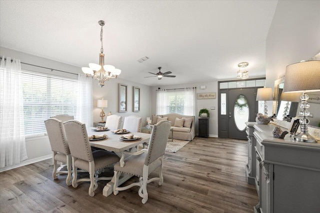 dining room featuring hardwood / wood-style flooring and ceiling fan with notable chandelier