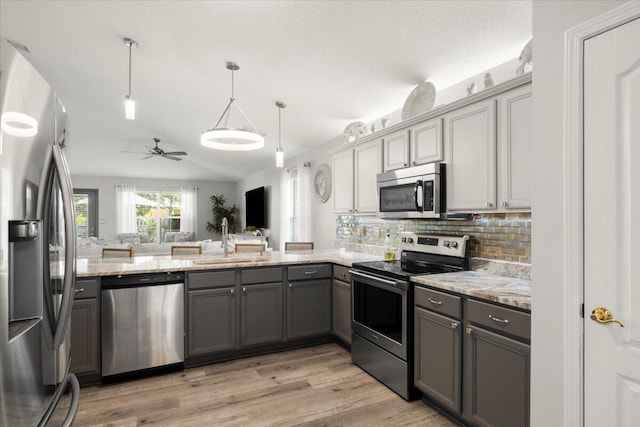 kitchen with sink, gray cabinets, hanging light fixtures, and appliances with stainless steel finishes