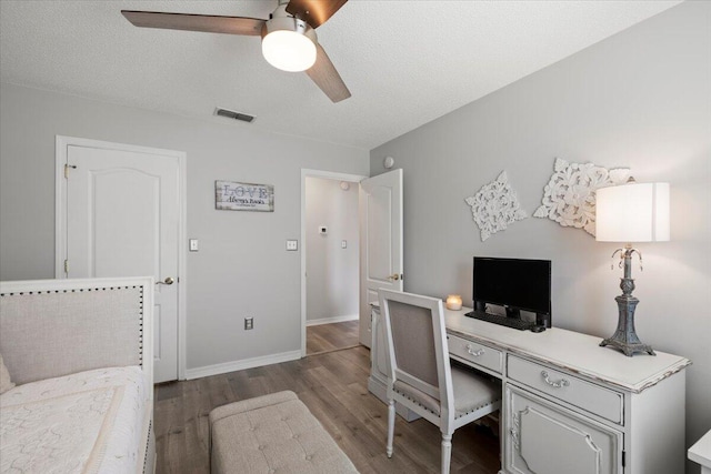 home office with ceiling fan, wood-type flooring, and a textured ceiling