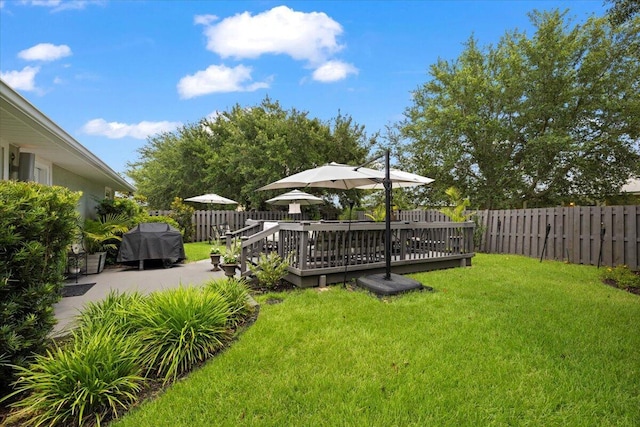 view of yard with a wooden deck and a patio