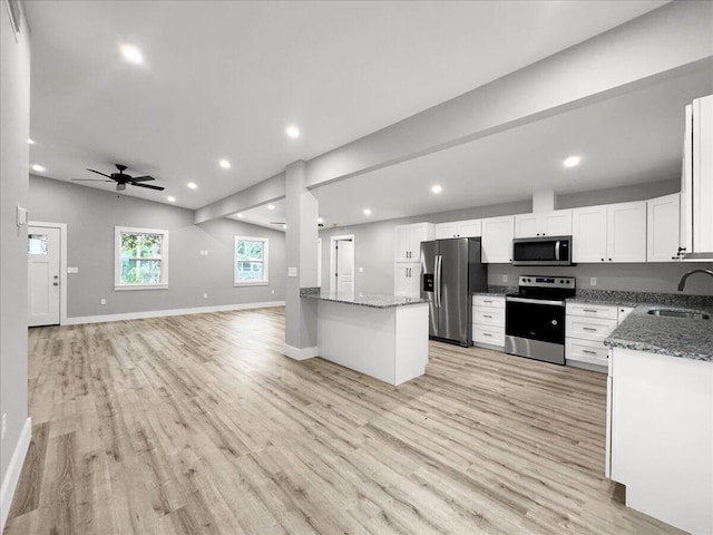 kitchen with sink, ceiling fan, stone counters, white cabinetry, and stainless steel appliances