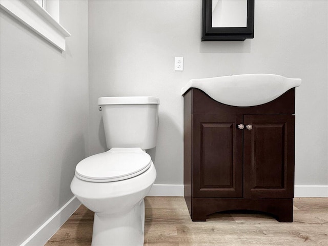 bathroom with vanity, toilet, and hardwood / wood-style floors