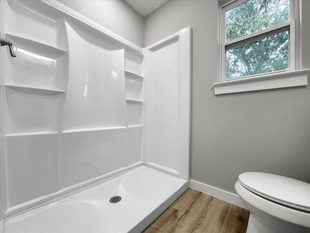 bathroom featuring toilet, hardwood / wood-style floors, and a shower