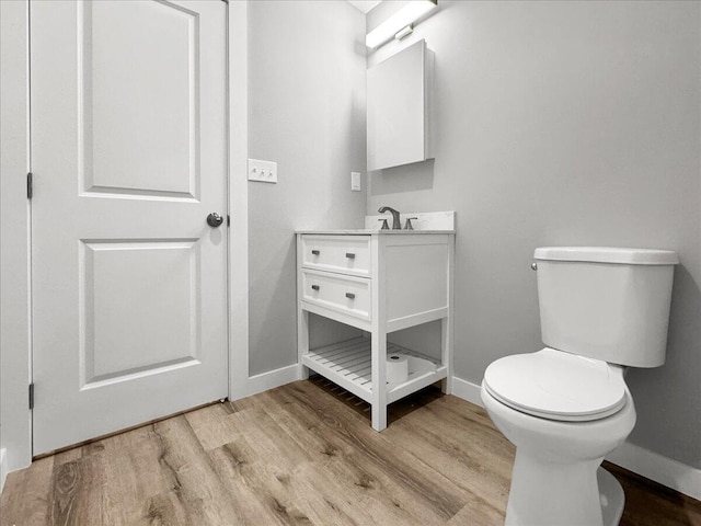 bathroom with vanity, toilet, and hardwood / wood-style floors