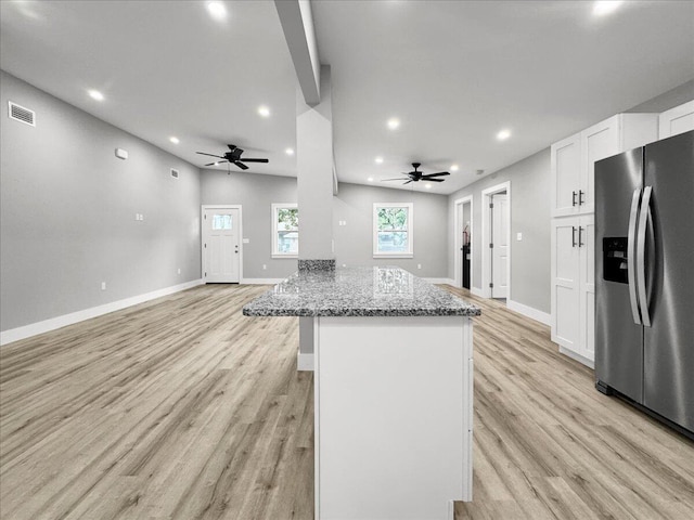 kitchen with ceiling fan, white cabinetry, dark stone countertops, stainless steel refrigerator with ice dispenser, and light hardwood / wood-style floors