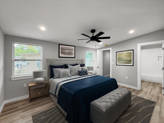 bedroom with ceiling fan, lofted ceiling, and light hardwood / wood-style flooring