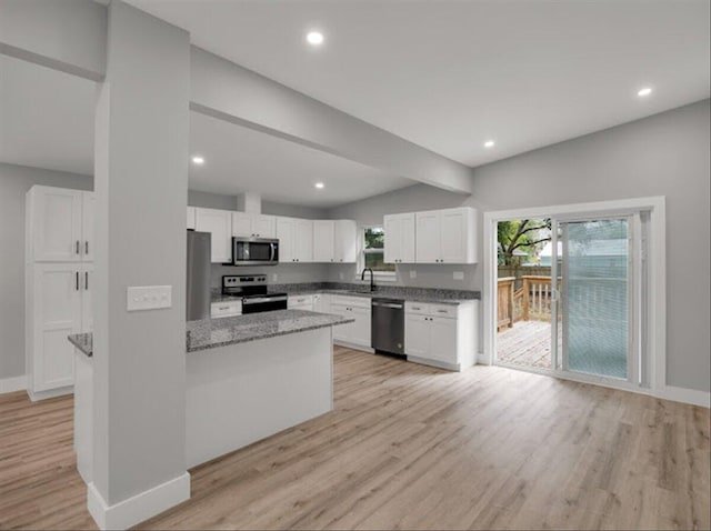 kitchen featuring stone counters, appliances with stainless steel finishes, white cabinets, and light hardwood / wood-style floors