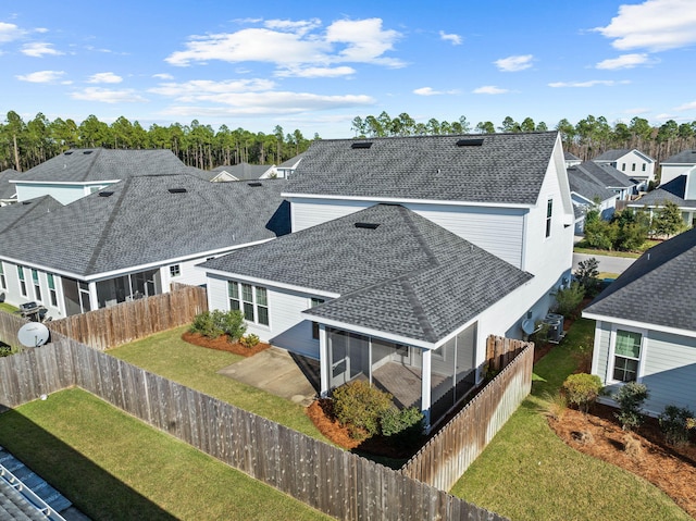 rear view of house with a yard and a sunroom