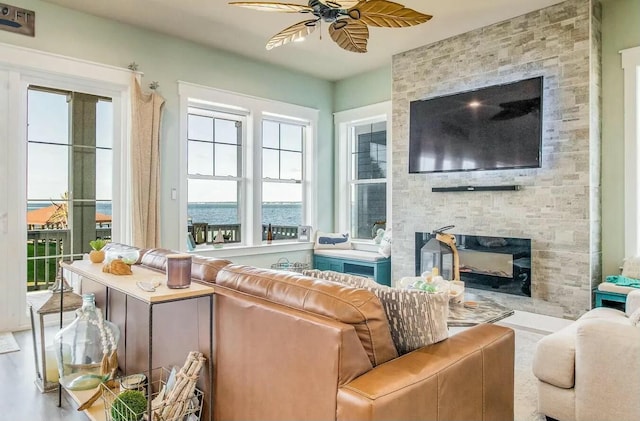 living room with ceiling fan and a fireplace