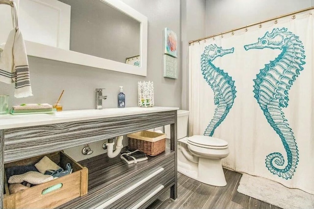 bathroom with sink, wood-type flooring, and toilet