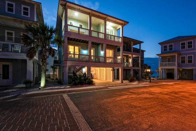 back house at dusk featuring a balcony