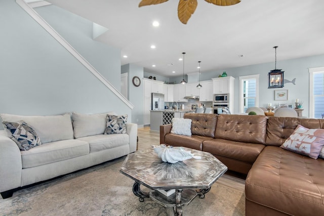 living room with light hardwood / wood-style floors and ceiling fan