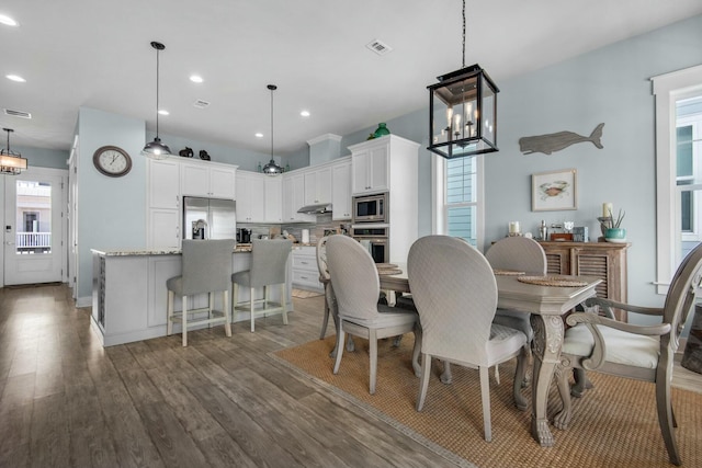 dining area with a chandelier, dark hardwood / wood-style flooring, and a healthy amount of sunlight