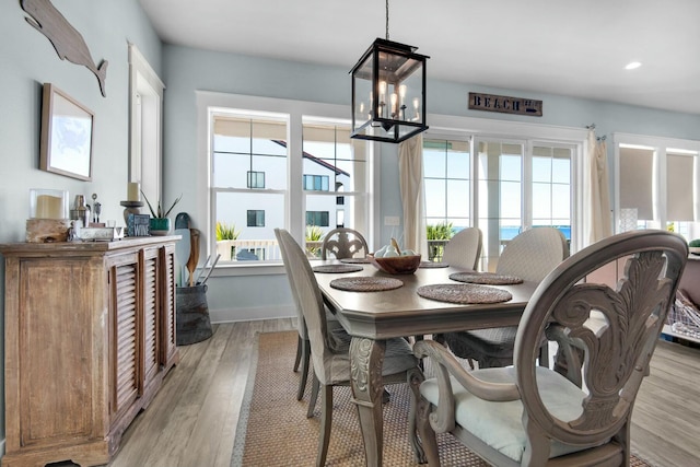 dining space with a notable chandelier and light hardwood / wood-style flooring