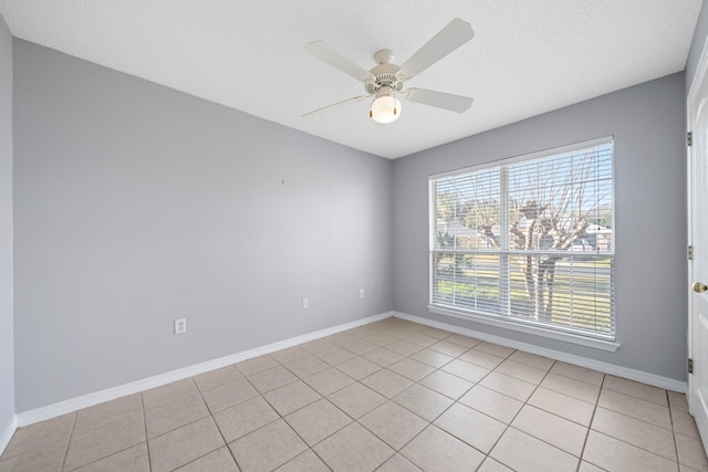 spare room with ceiling fan, light tile patterned floors, and a textured ceiling