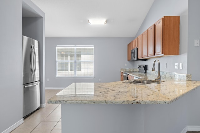 kitchen featuring light stone countertops, stainless steel appliances, kitchen peninsula, vaulted ceiling, and light tile patterned floors